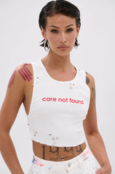 NEVER CARED DISTRESSED CROPPED TANK TOP